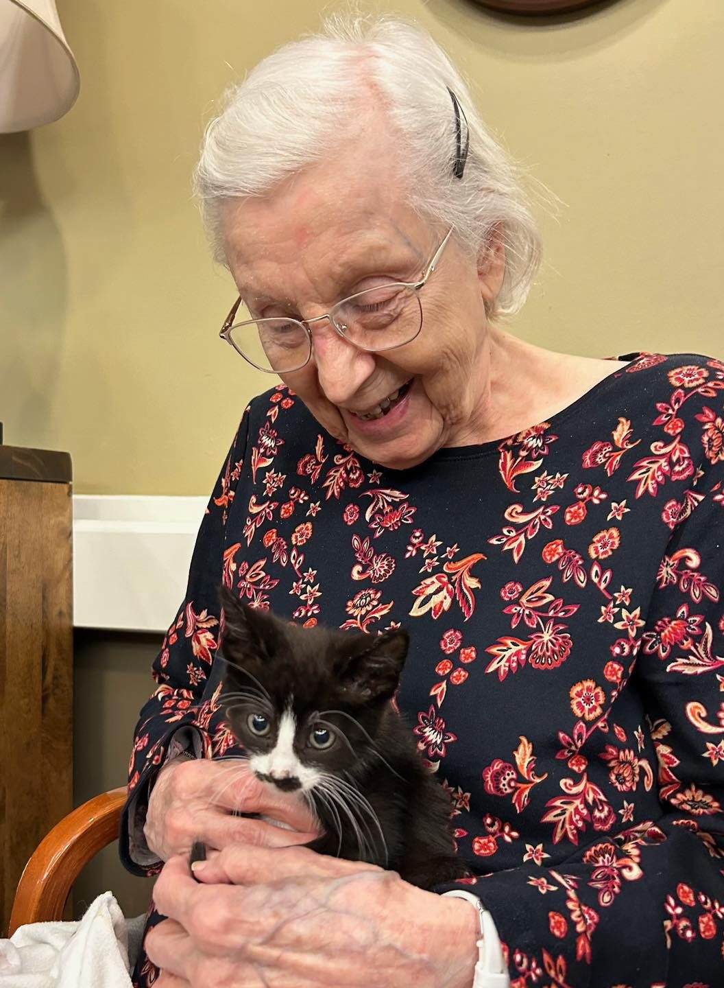 Resident enjoying time with a kitten.