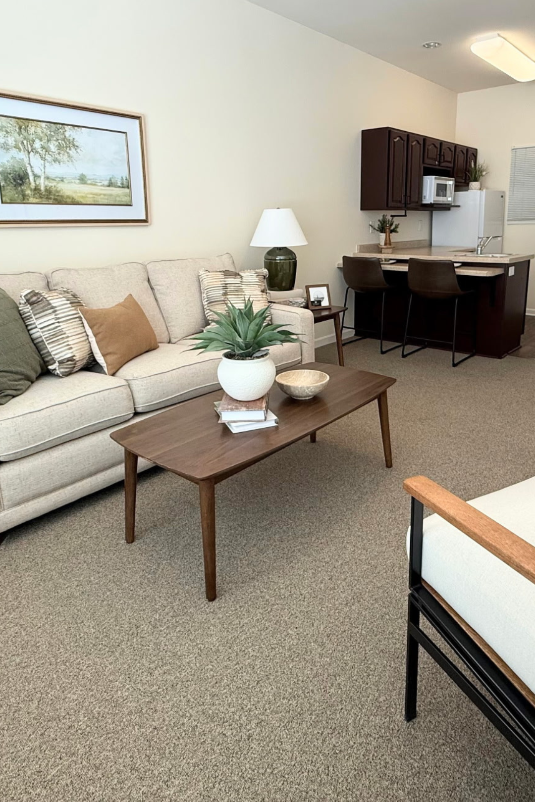 Cozy living area with a sofa and kitchen in the background
