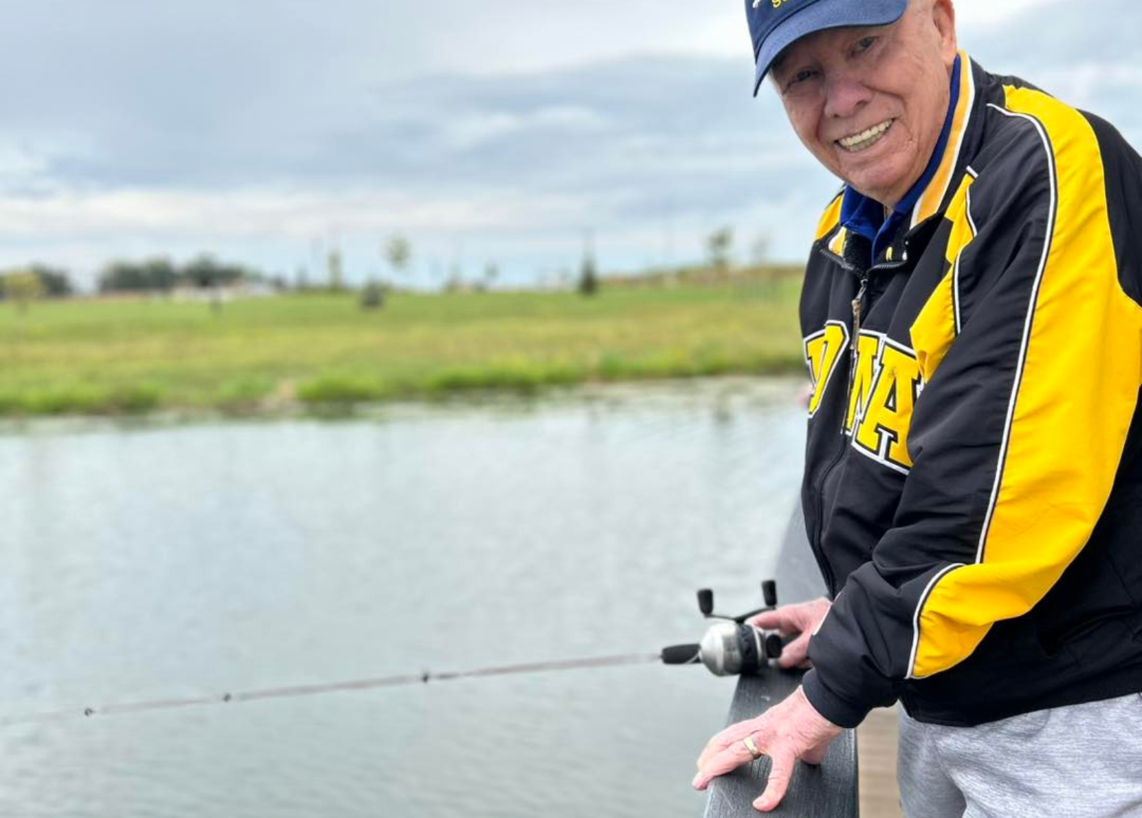 Senior man fishing by a lake in a park