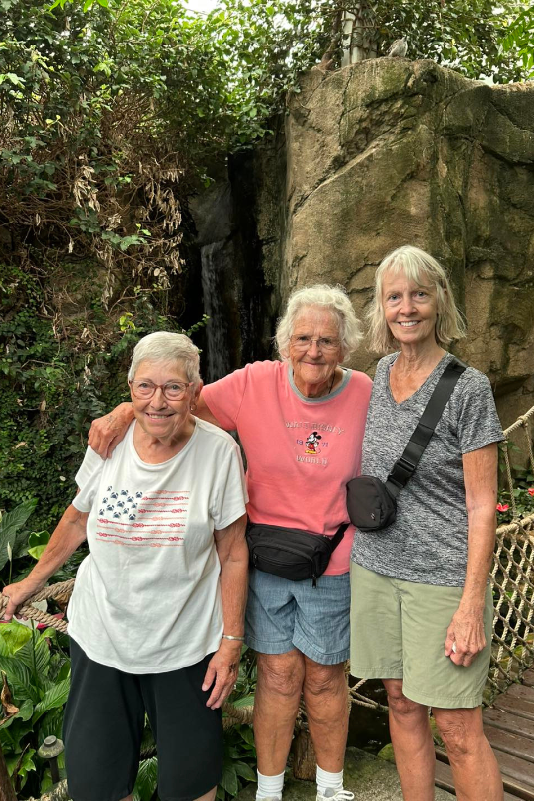 Three residents posing together in a garden area