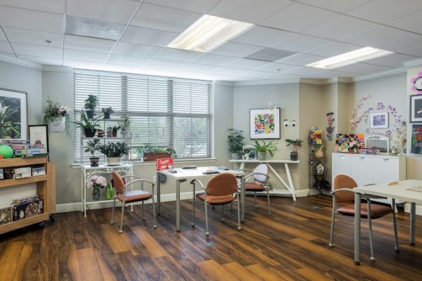 Bright common area with plants and tables.