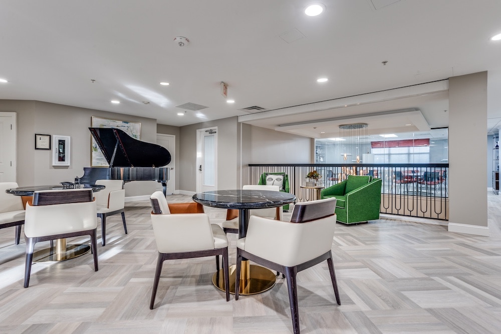 Bright common area with seating and a grand piano