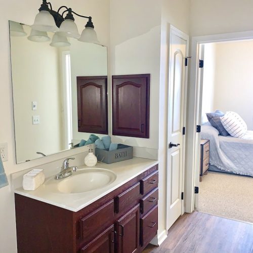 Well-lit bathroom and bedroom area in a resident room
