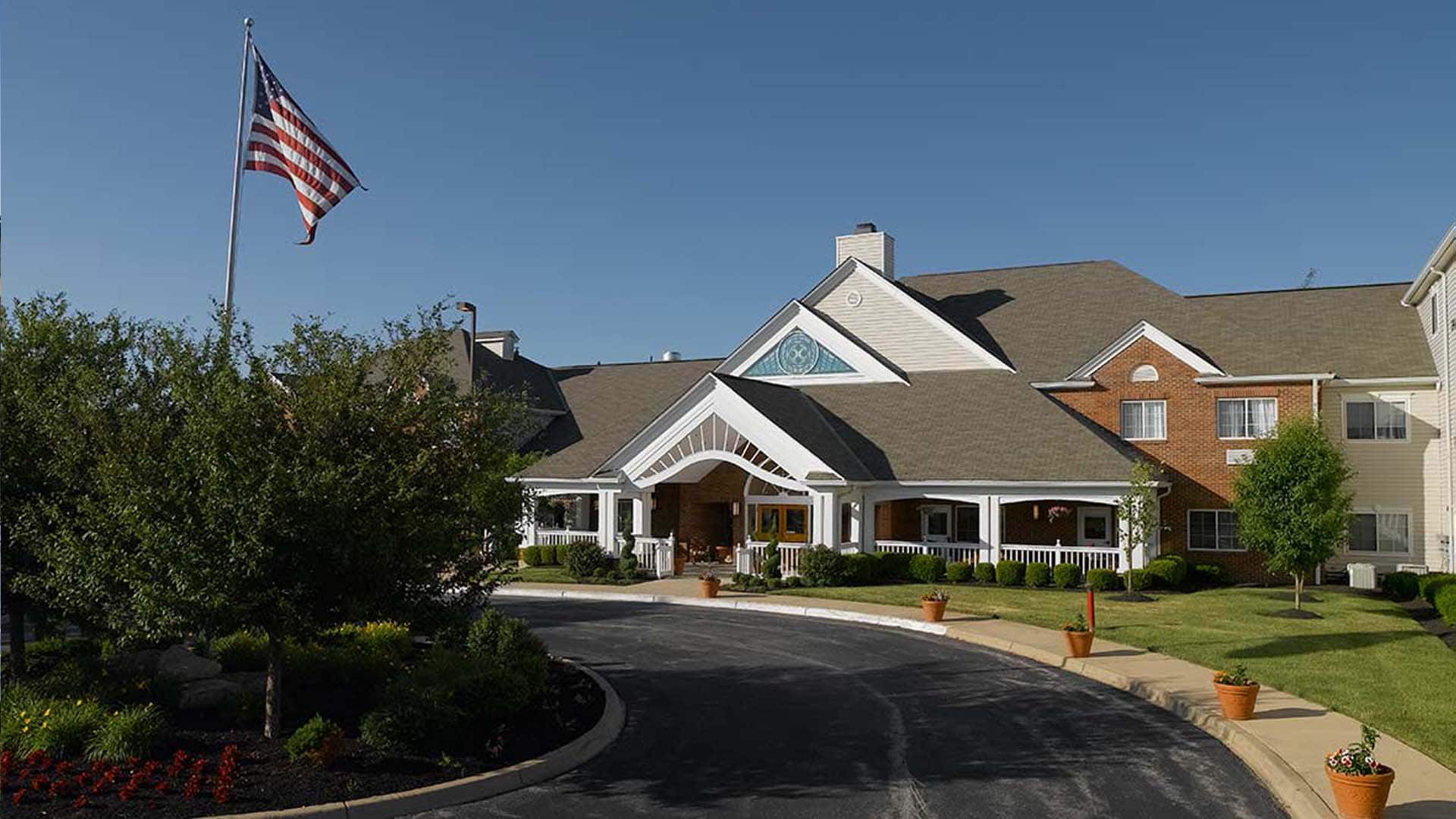 Exterior view of a senior living facility with flag