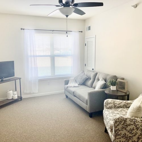 Cozy interior of a resident room with sofa and TV