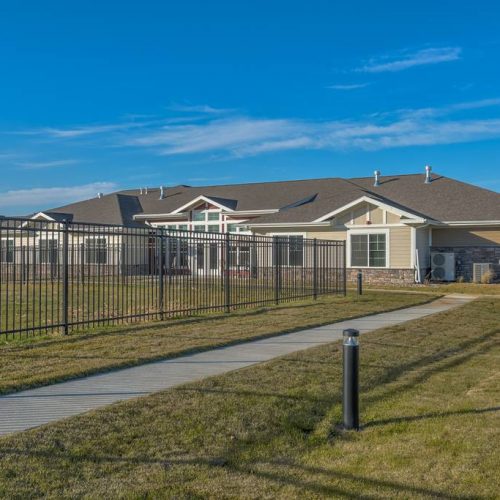 Exterior view of the facility with a fence and walkway