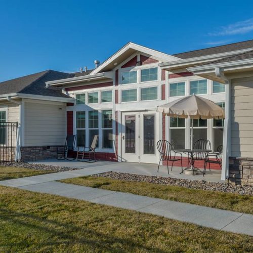 Exterior view of a senior living facility with outdoor seating
