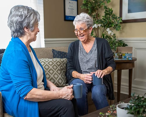 Two residents enjoying coffee and conversation in a cozy sitting area