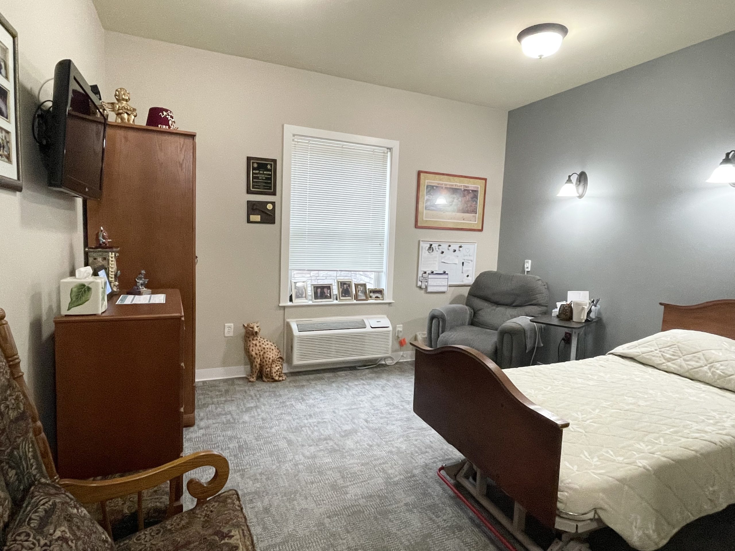 A cozy resident room with a bed and chair