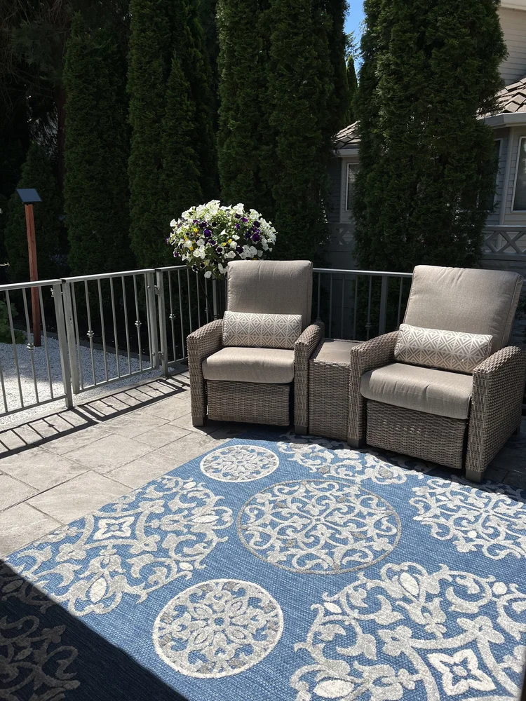 Outdoor seating area with chairs and decorative rug