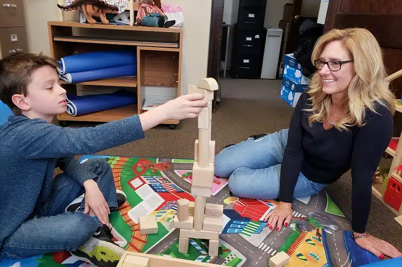 Adult and child playing with block toys