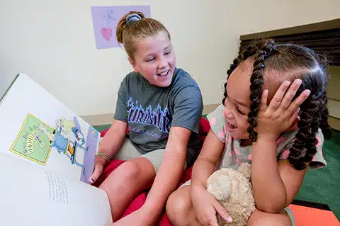 Children reading together in a cozy space.