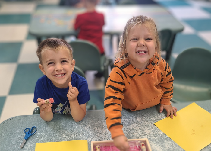 Two children engaging in an art activity indoors.