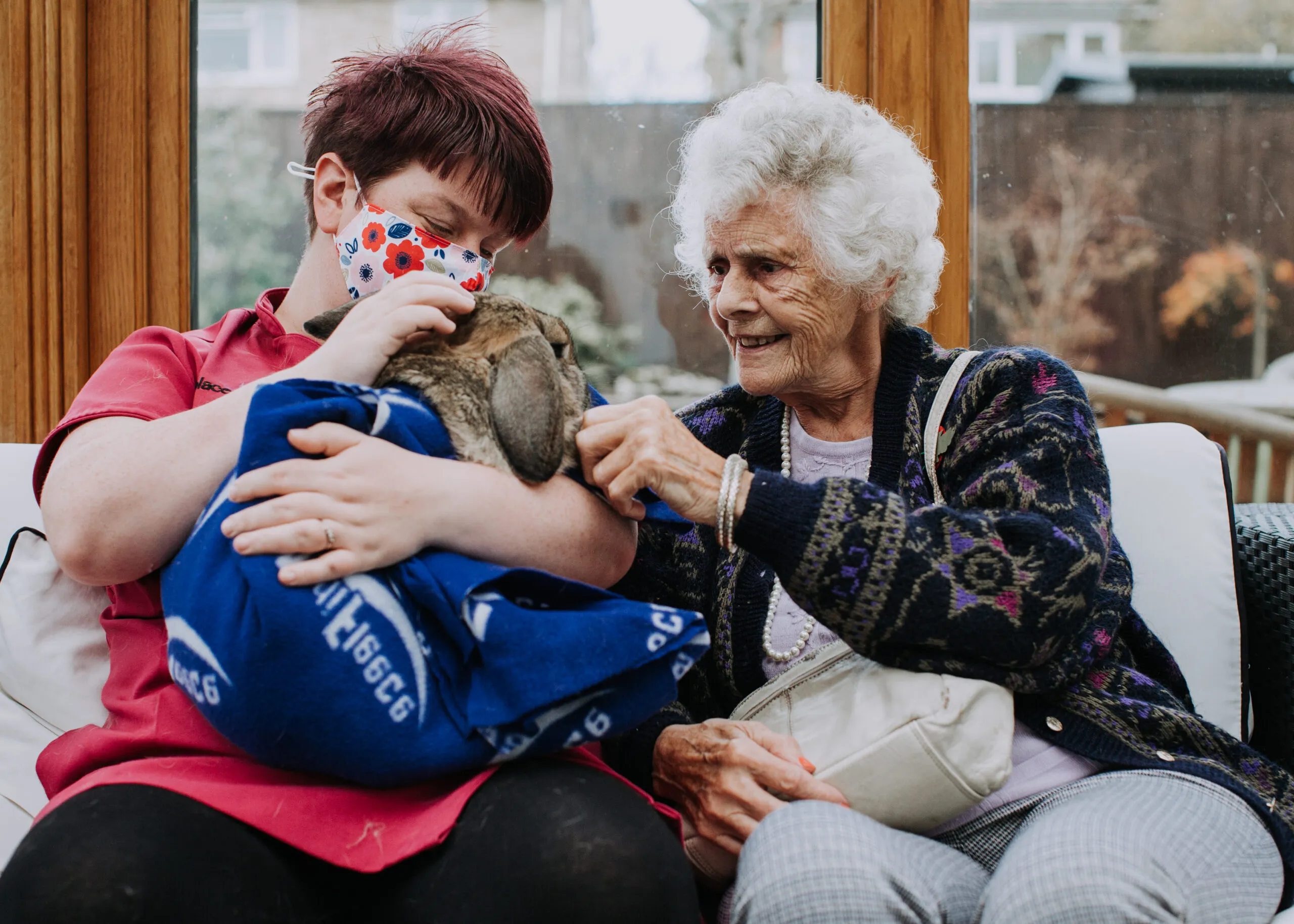 Staff member holding a rabbit with a resident