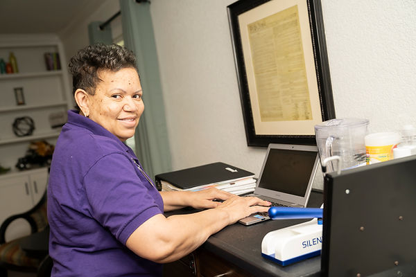 Staff member working on a laptop at a desk.