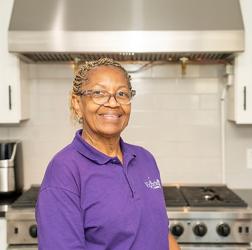 Staff member smiling in a kitchen setting