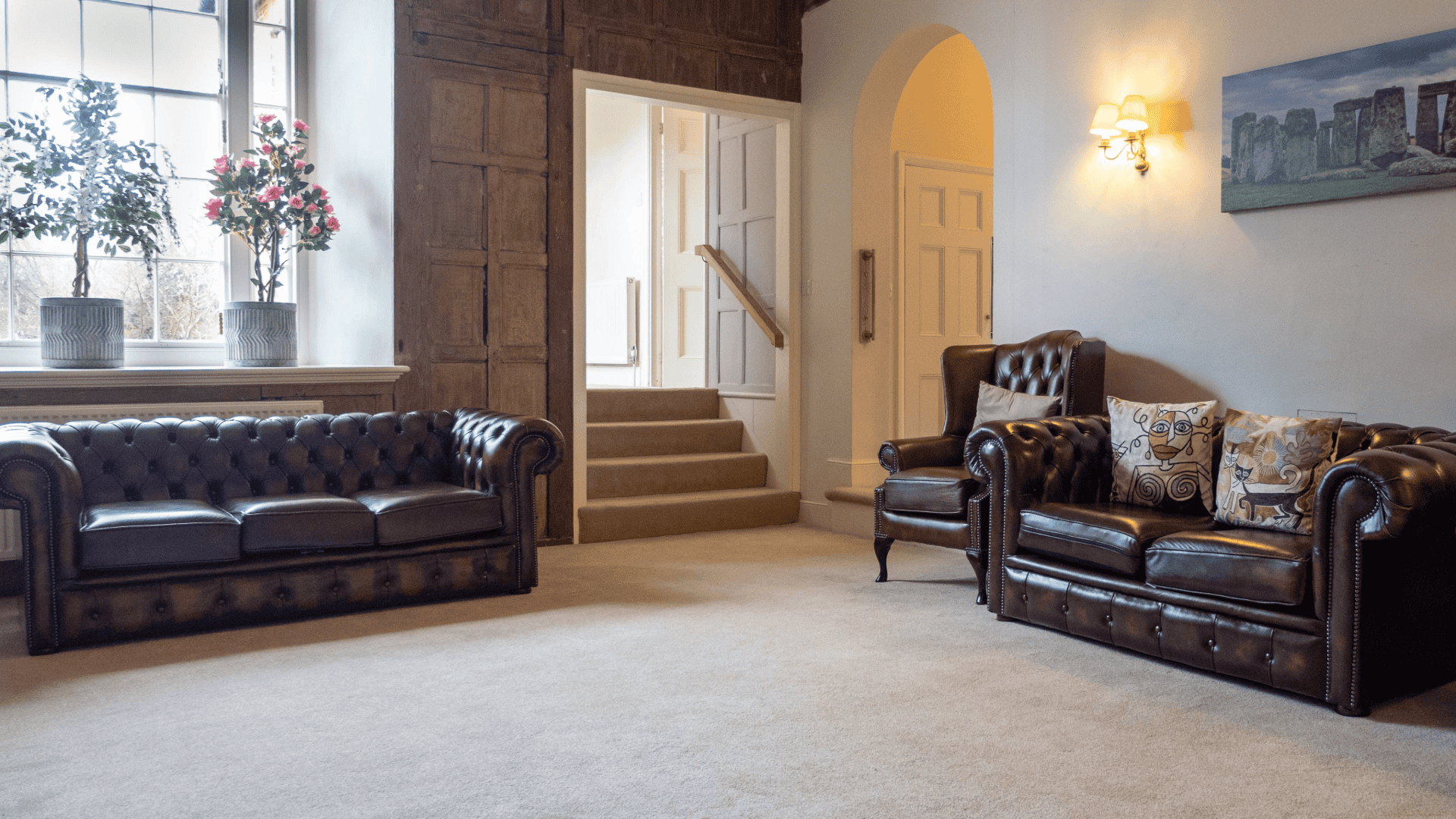Cozy common area with leather couches and decorative pillows.