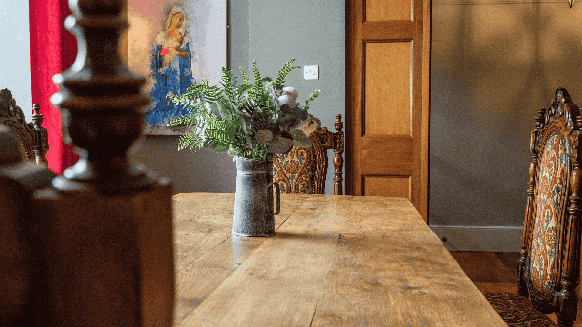 Dining area with a wooden table and decorative chairs.