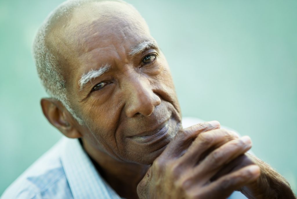 Senior man thoughtfully resting his chin on his hands
