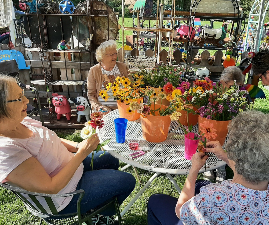 Residents engaging in flower arrangement outdoors.