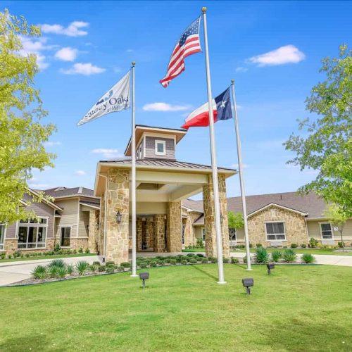 Exterior view of Cambridge Court Senior Living entrance with flags