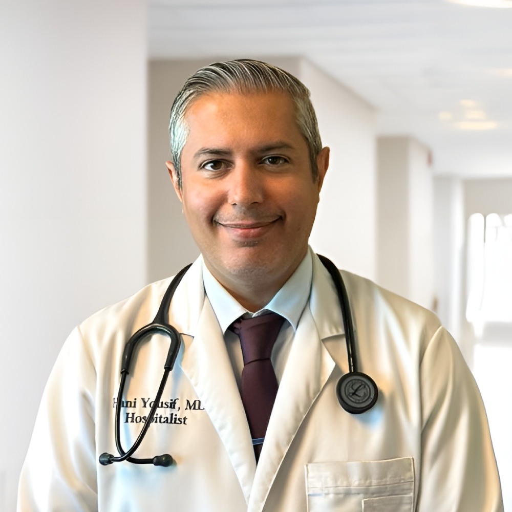 A doctor posing in a bright facility corridor