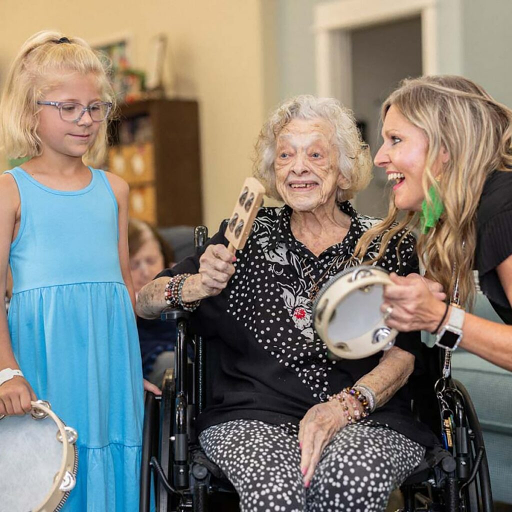 Residents engaging in a music activity with young visitors