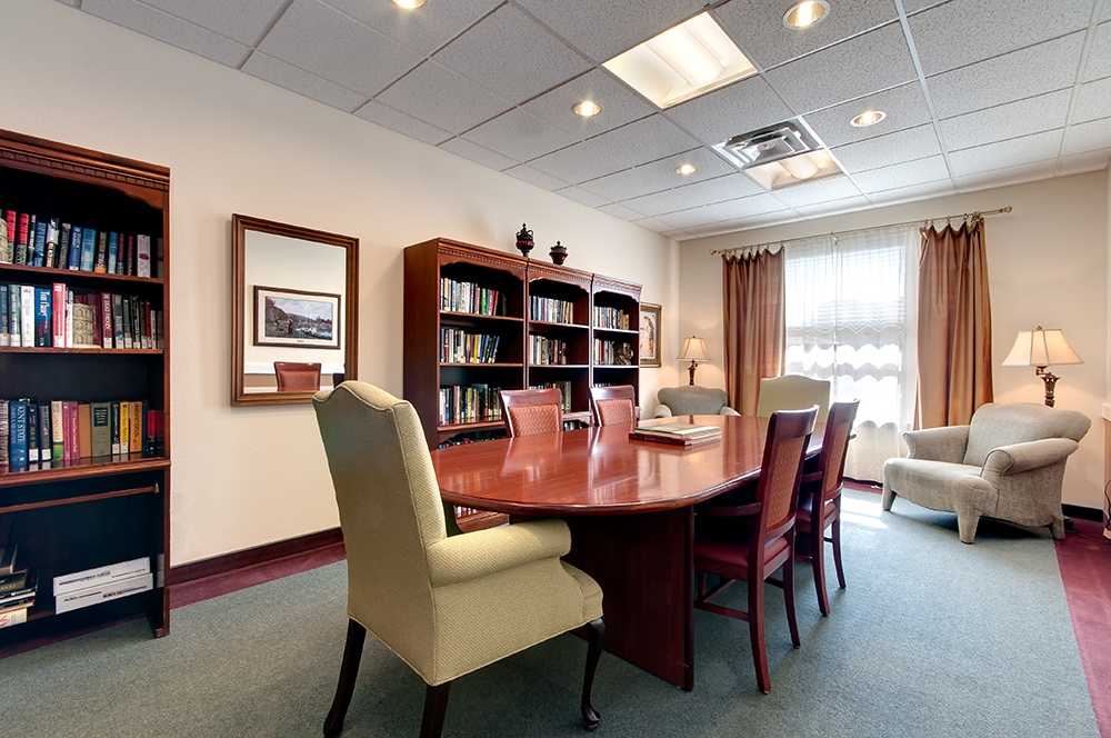 Common area with bookshelves and a meeting table