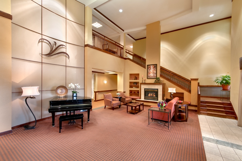 Interior view of a cozy common area with seating and piano