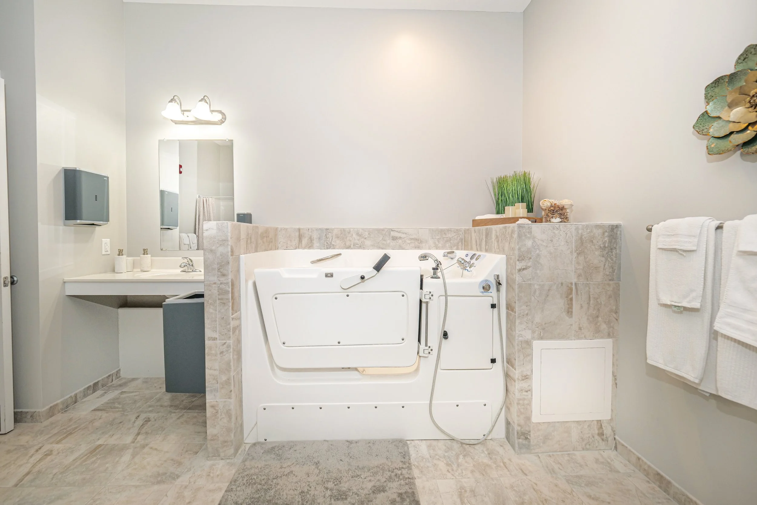Well-equipped accessible bathroom with tub.