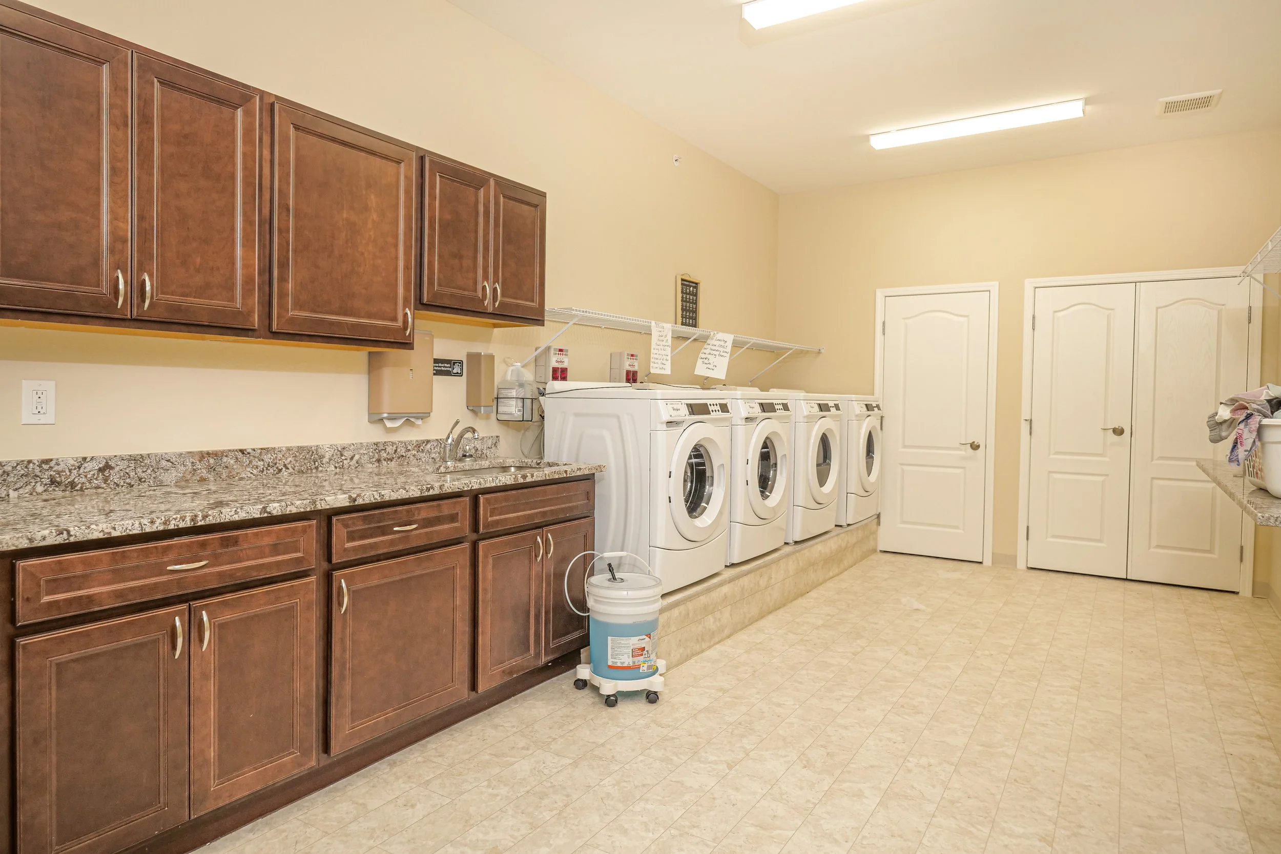 Clean laundry room with washing machines and cabinets.