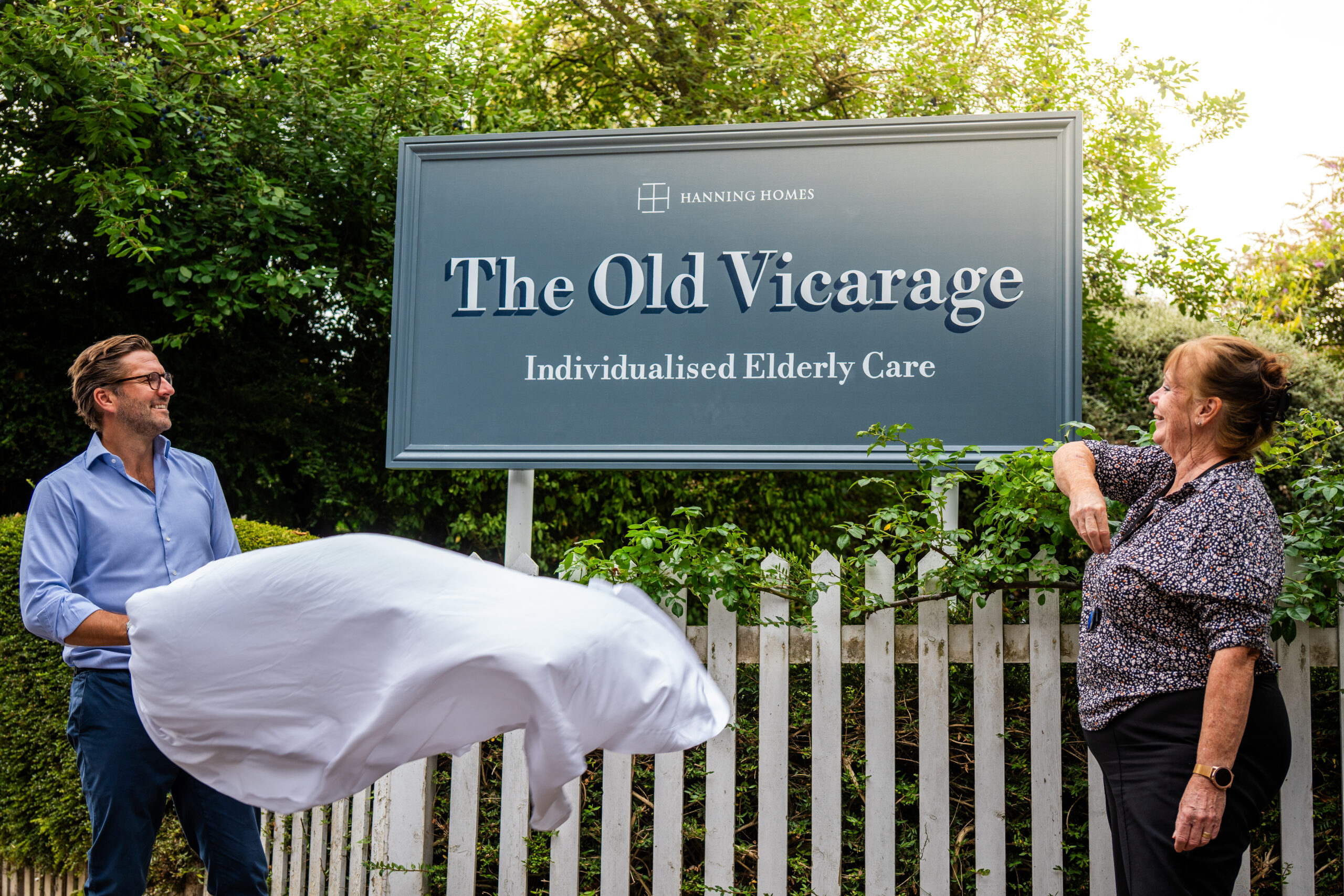 Staff members unveiling a sign at the facility entrance.