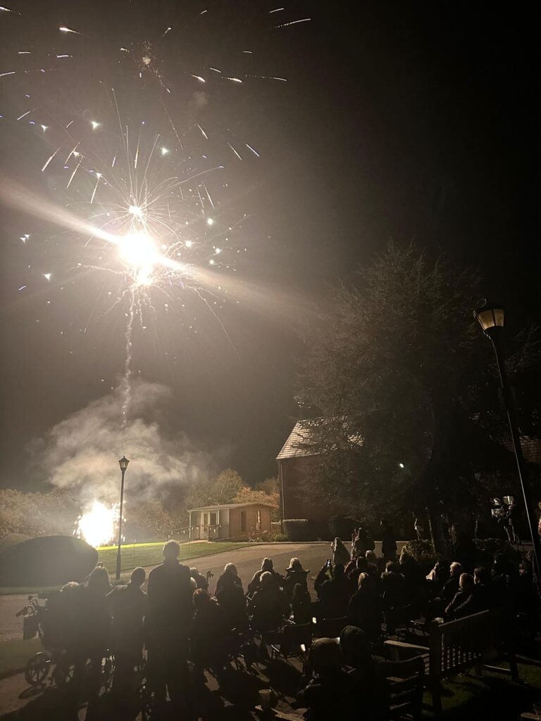 Residents enjoying a fireworks display outdoors.