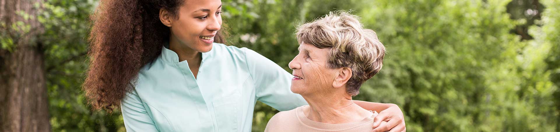Caregiver interacting with an elderly resident outdoors