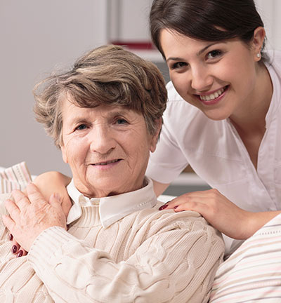 Caregiver with senior resident smiling together
