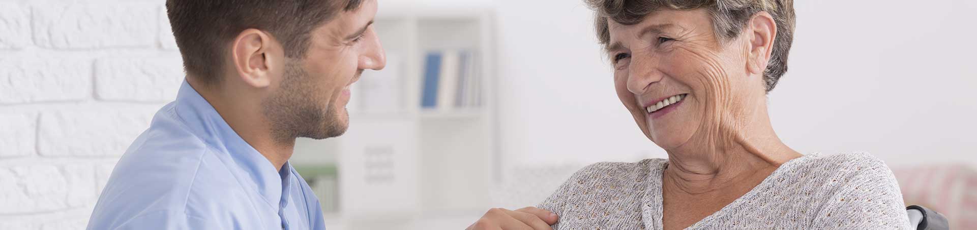 Caregiver smiling with a resident in a bright room