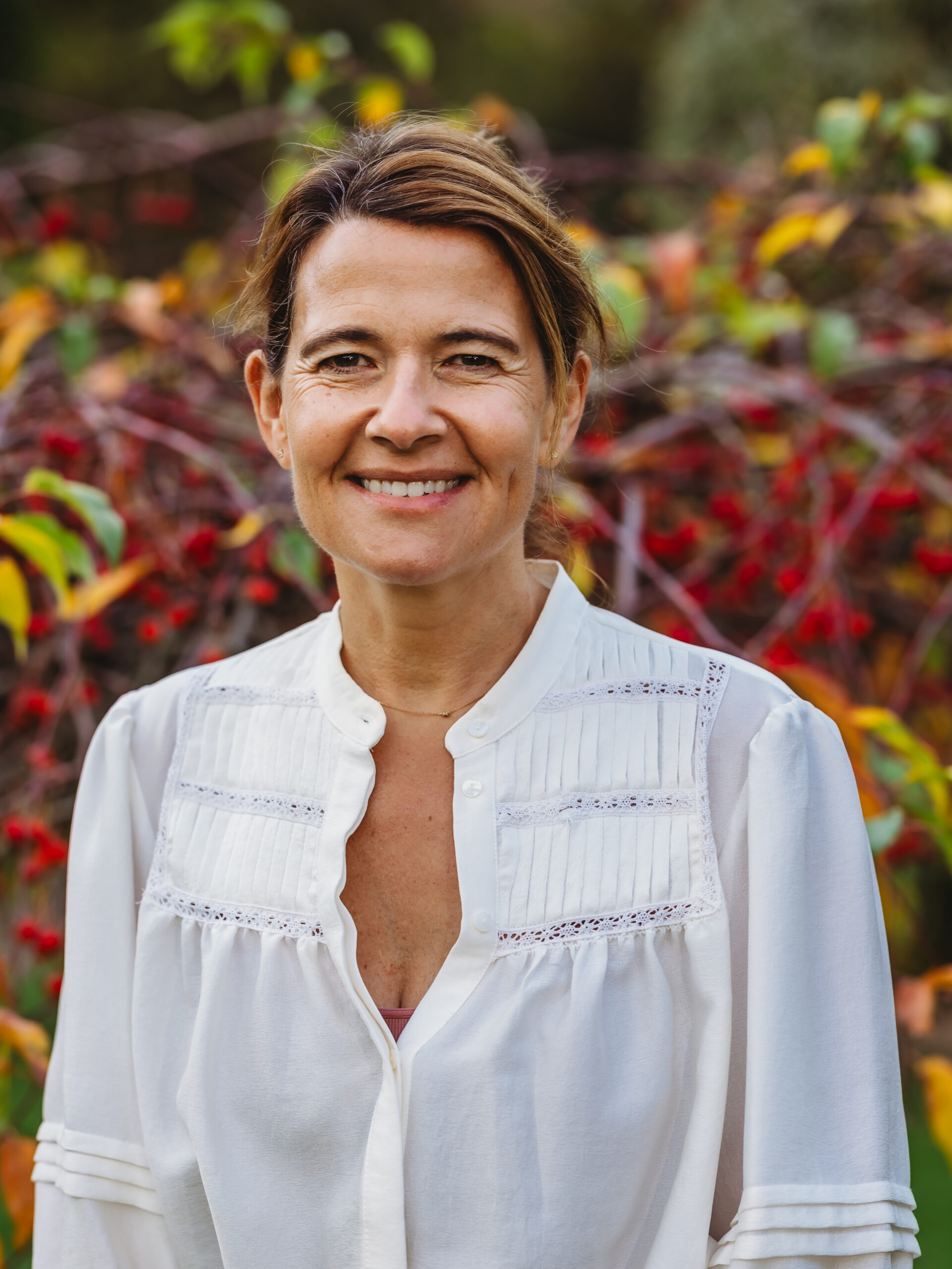 Smiling woman outdoors with natural background.