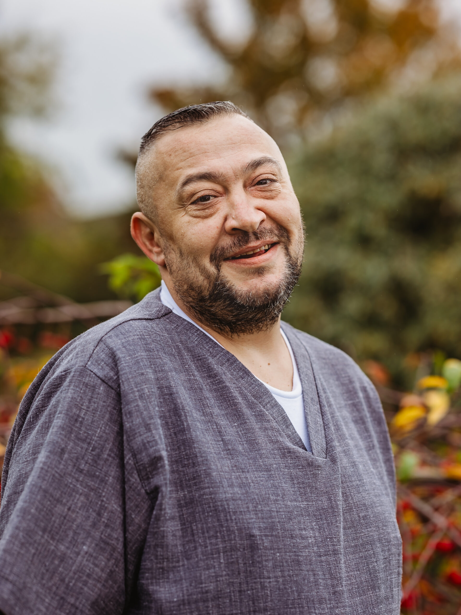 Smiling staff member in a garden setting