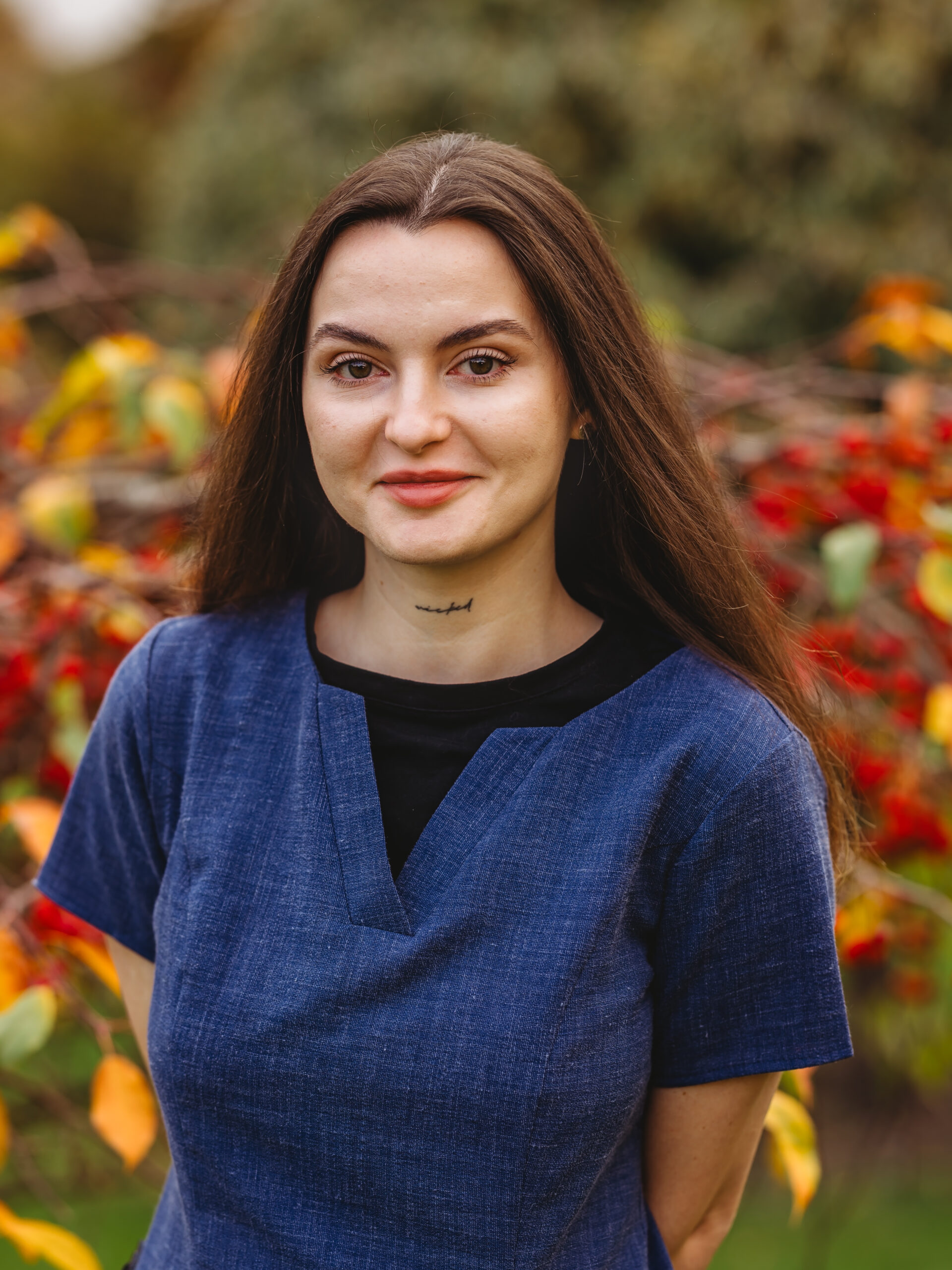 Staff member posing outside with autumn foliage