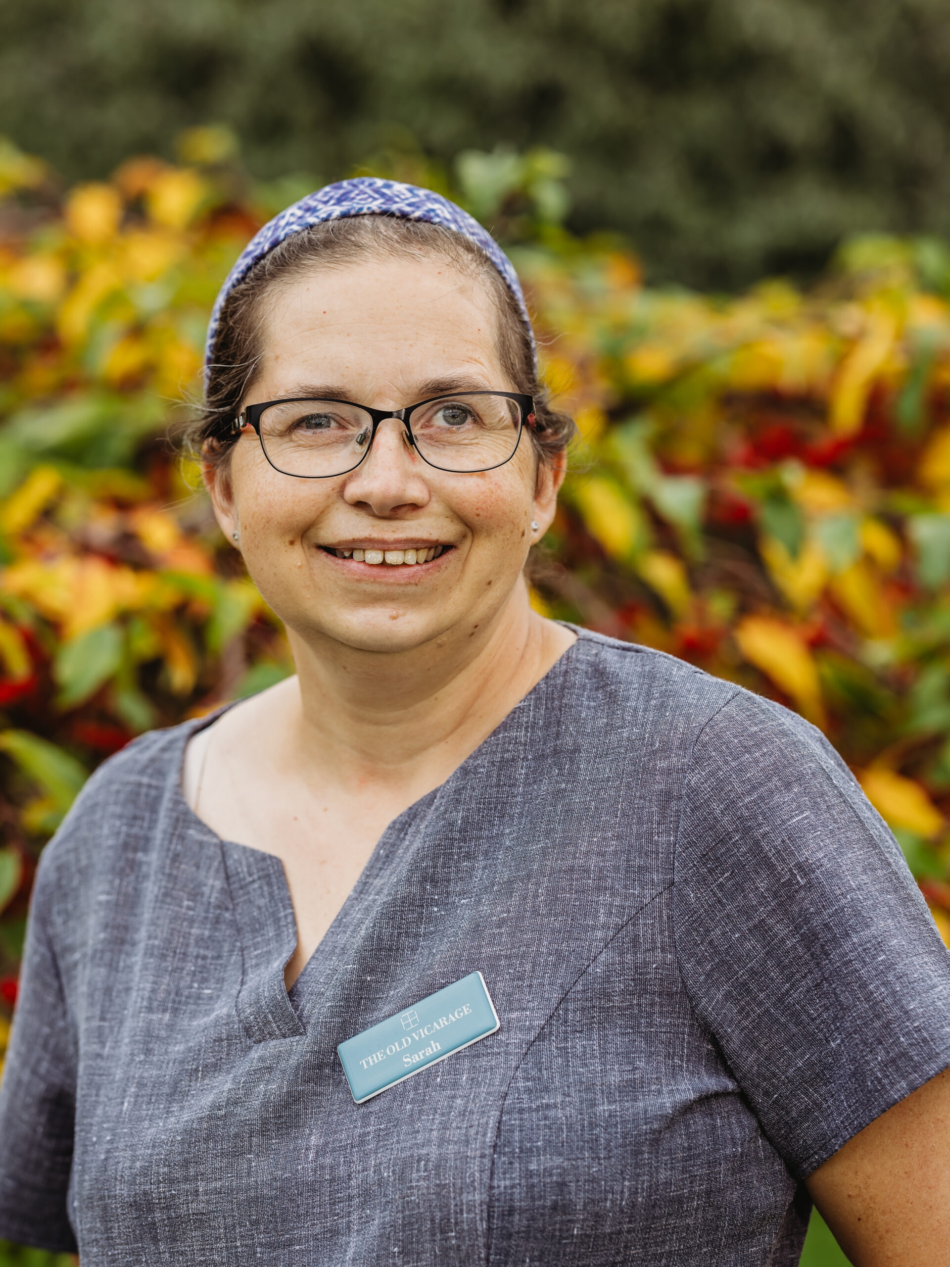 Staff member smiling in a garden area