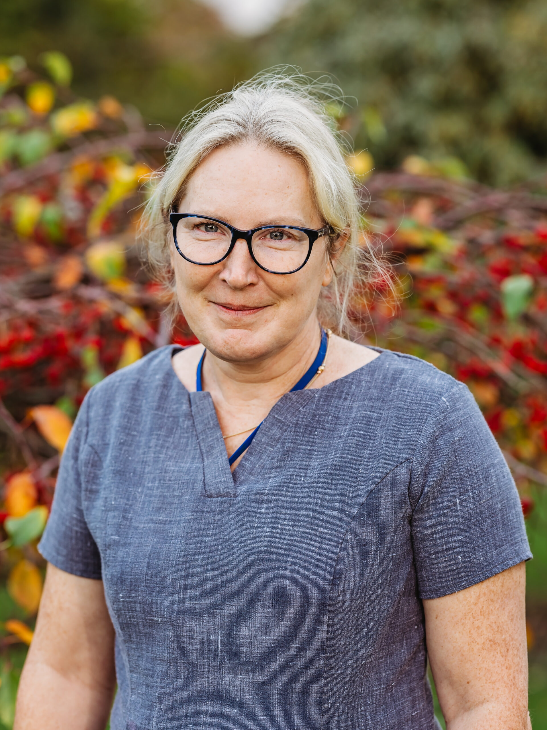 Staff member in front of colorful foliage