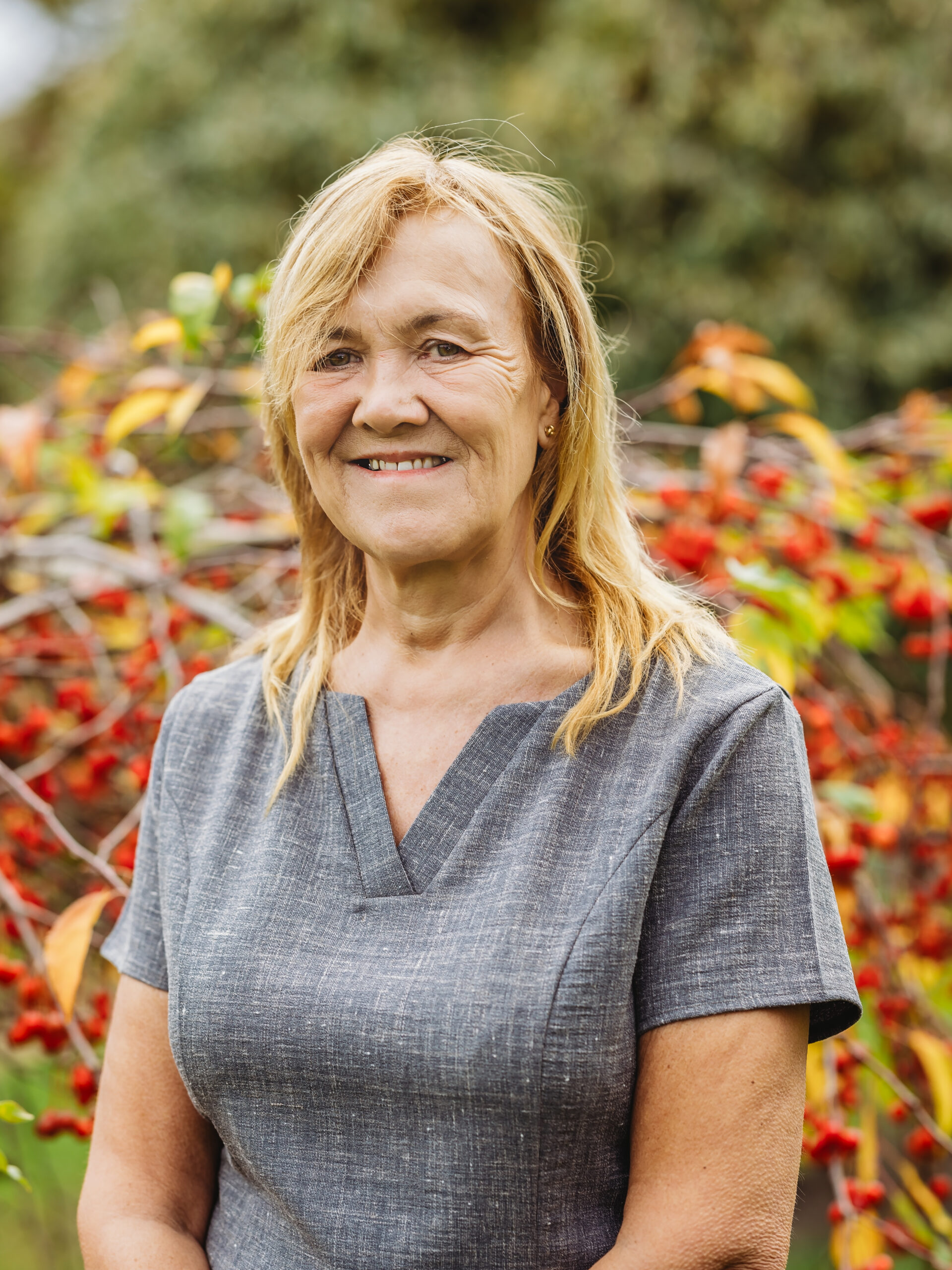 Smiling staff member in a vibrant outdoor garden