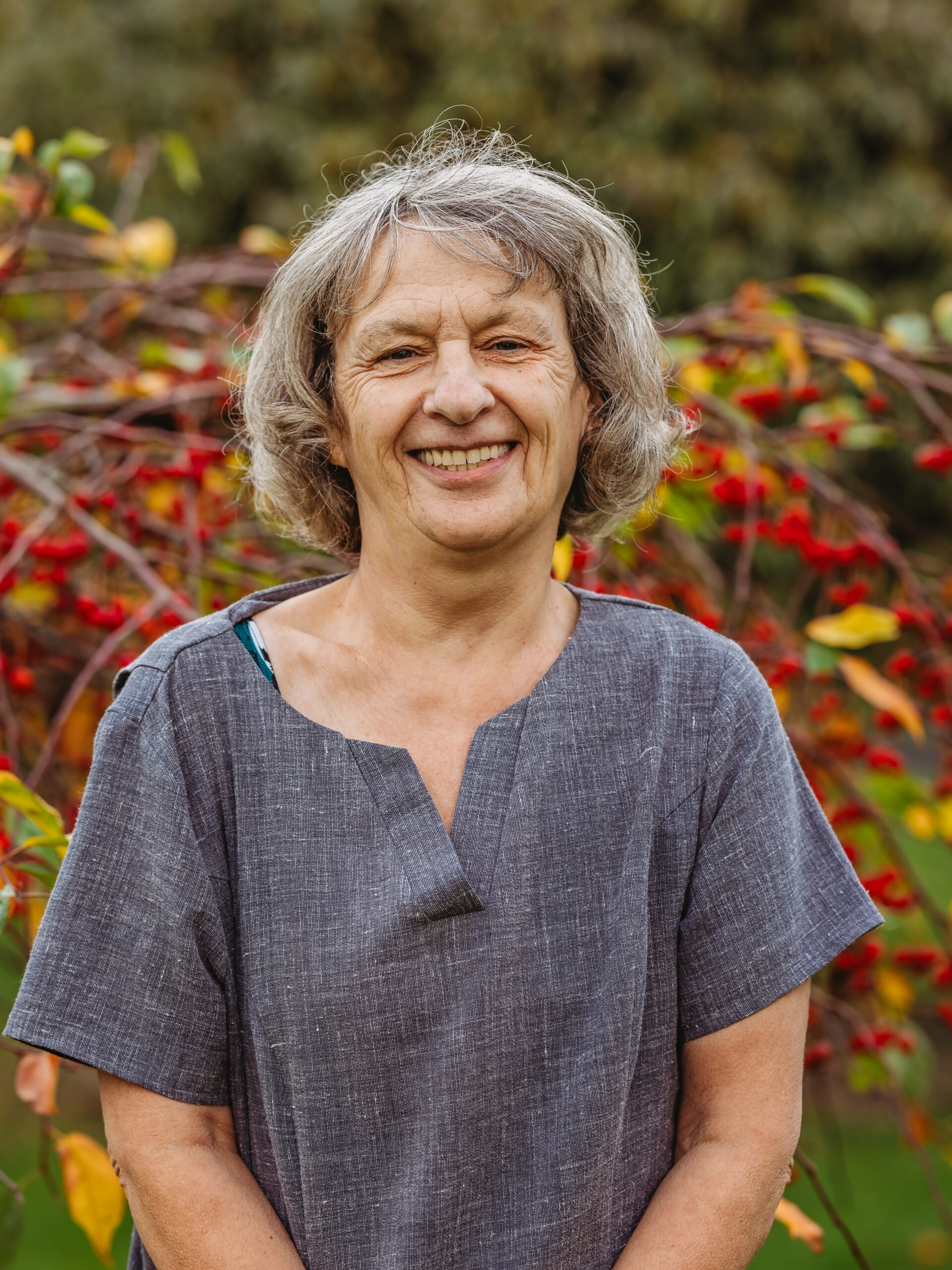 Smiling staff member in a garden setting