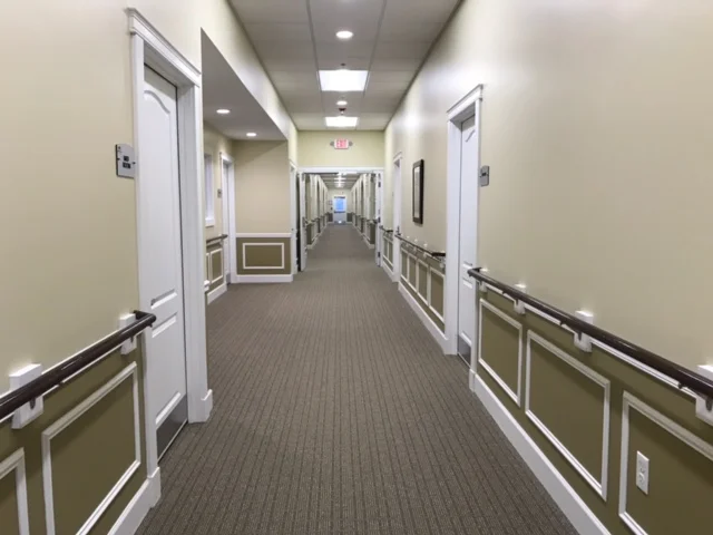 Empty hallway with residential doors and handrails
