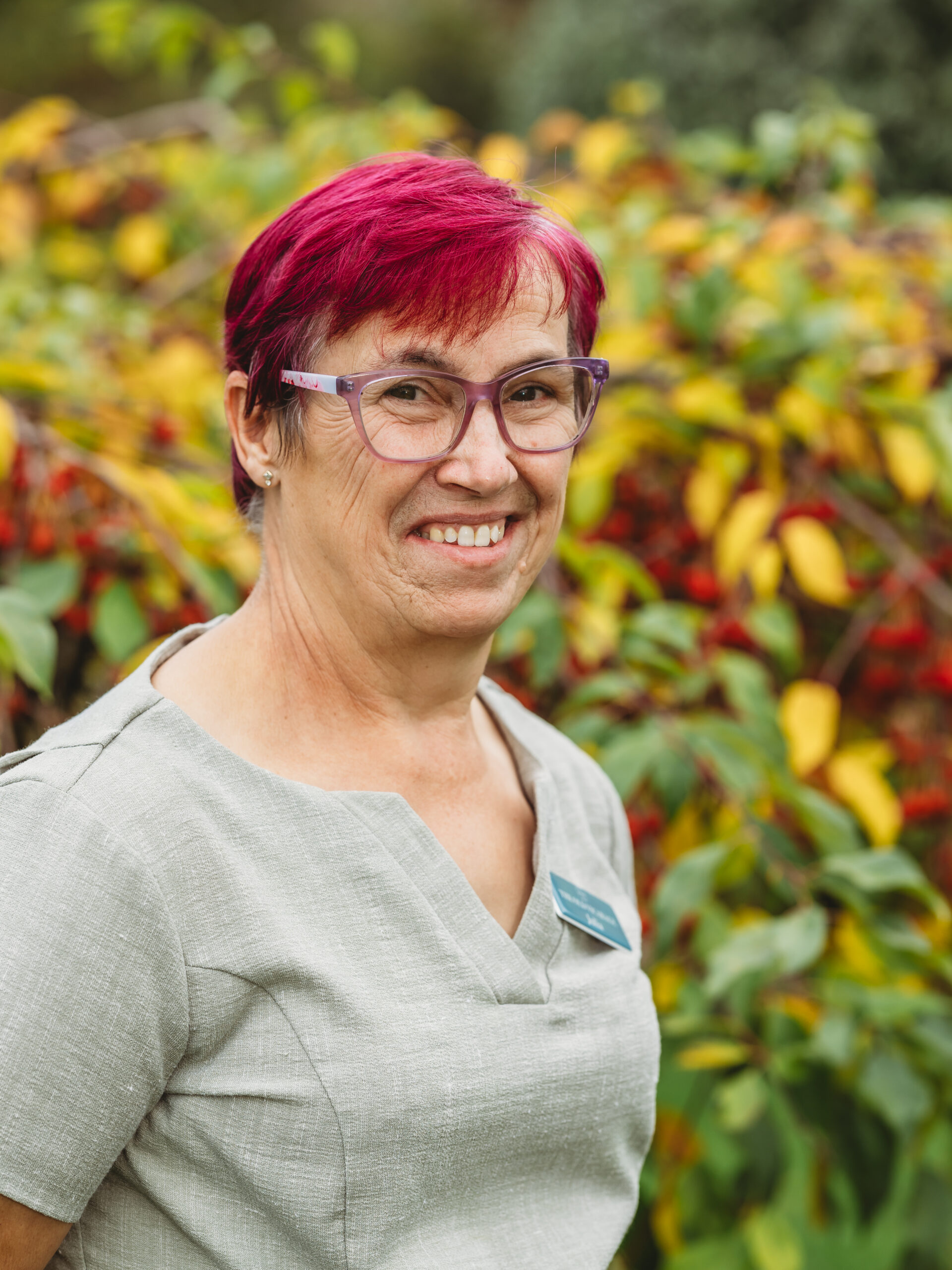 Staff member smiling in a garden setting