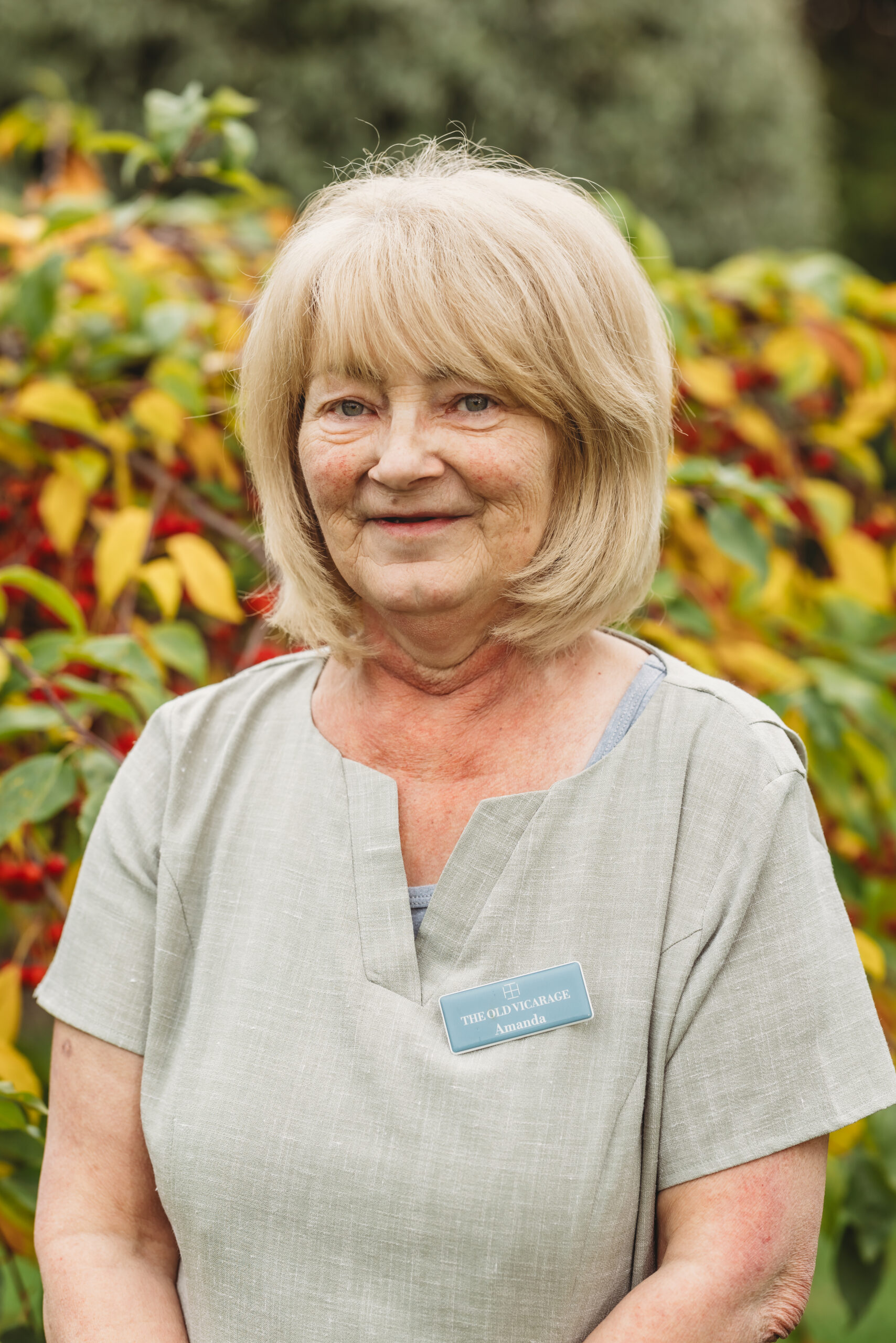 Staff member in front of colorful foliage