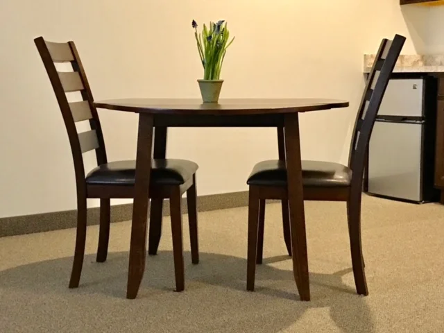 Small dining table set with chairs and flowers
