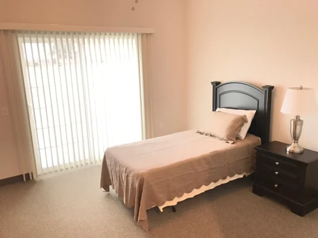 Private resident room with a bed and lamp.