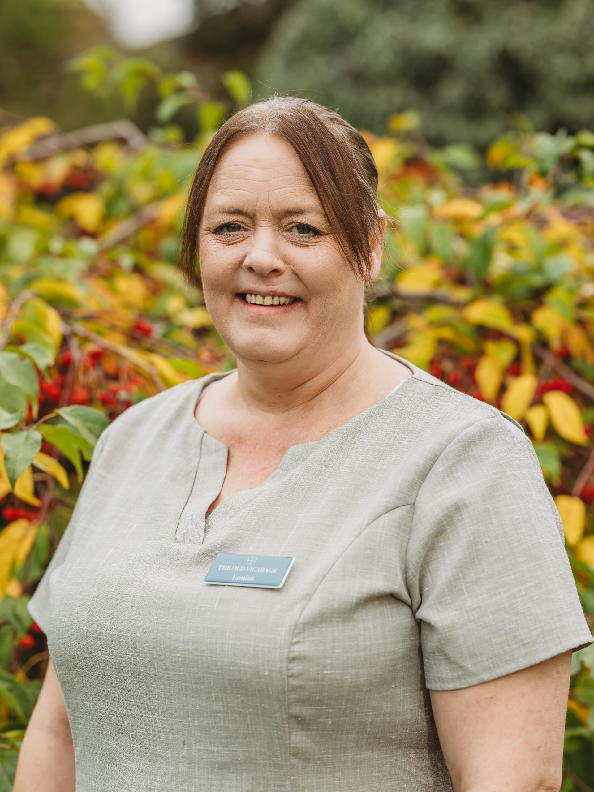 Staff member smiling outdoors in nature