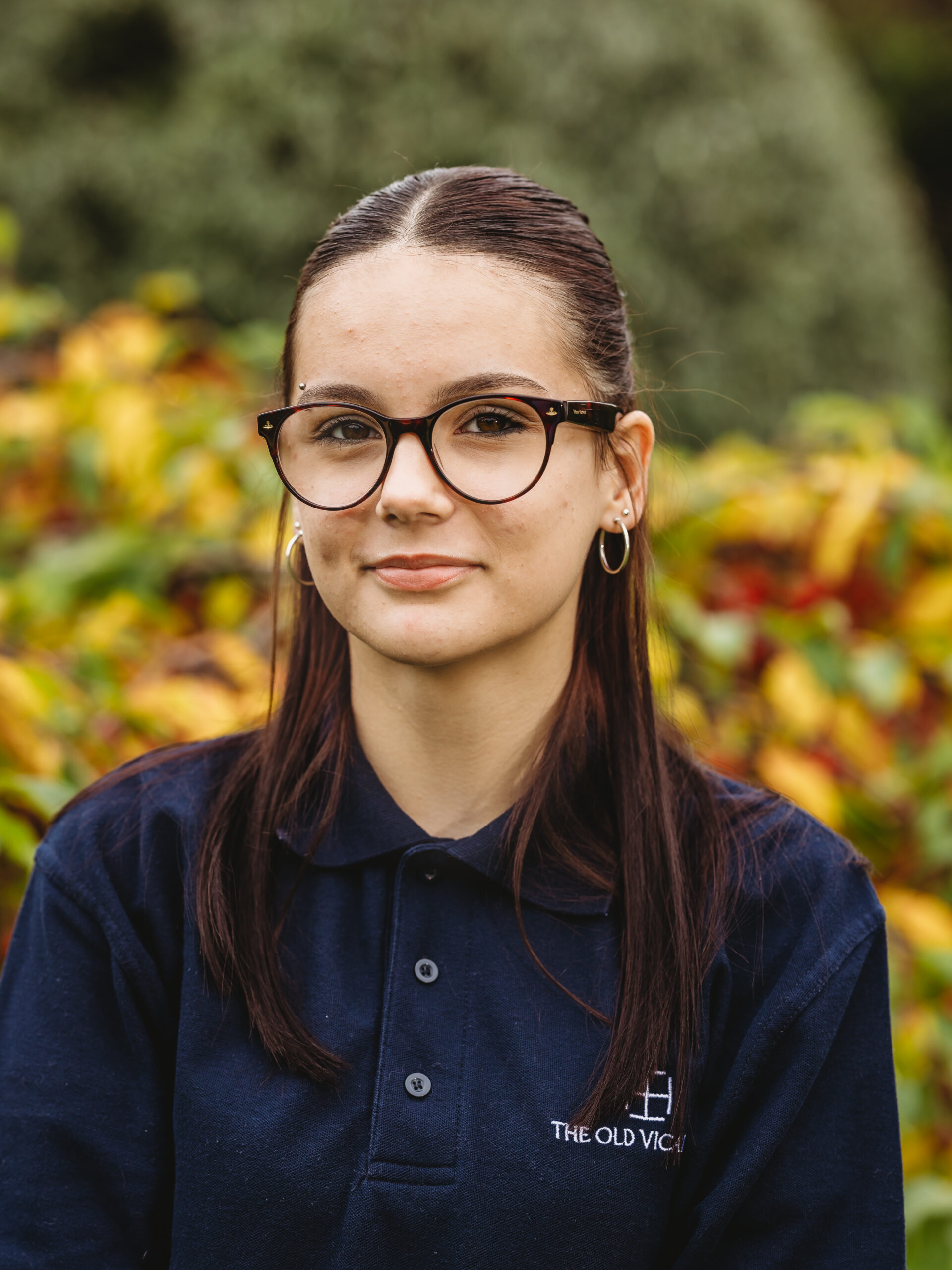 Staff member in Old Vicarage staff uniform outdoors.